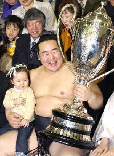 
Asashoryu holds the Emperor's Cup and his daughter. 
 (Associated Press / The Spokesman-Review)