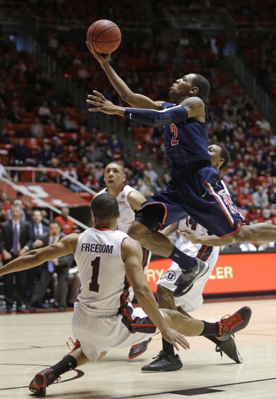 Arizona’s Mark Lyons goes to the basket as former EWU Eagle Glen Dean (1) tumbles in second-half action. (Associated Press)