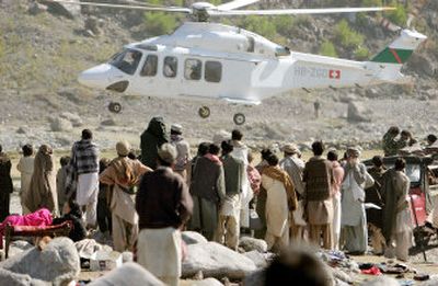 
Earthquake survivors watch as a medical helicopter lands to collect injured for evacuation from Balakot, Pakistan, on Friday. 
 (Associated Press / The Spokesman-Review)