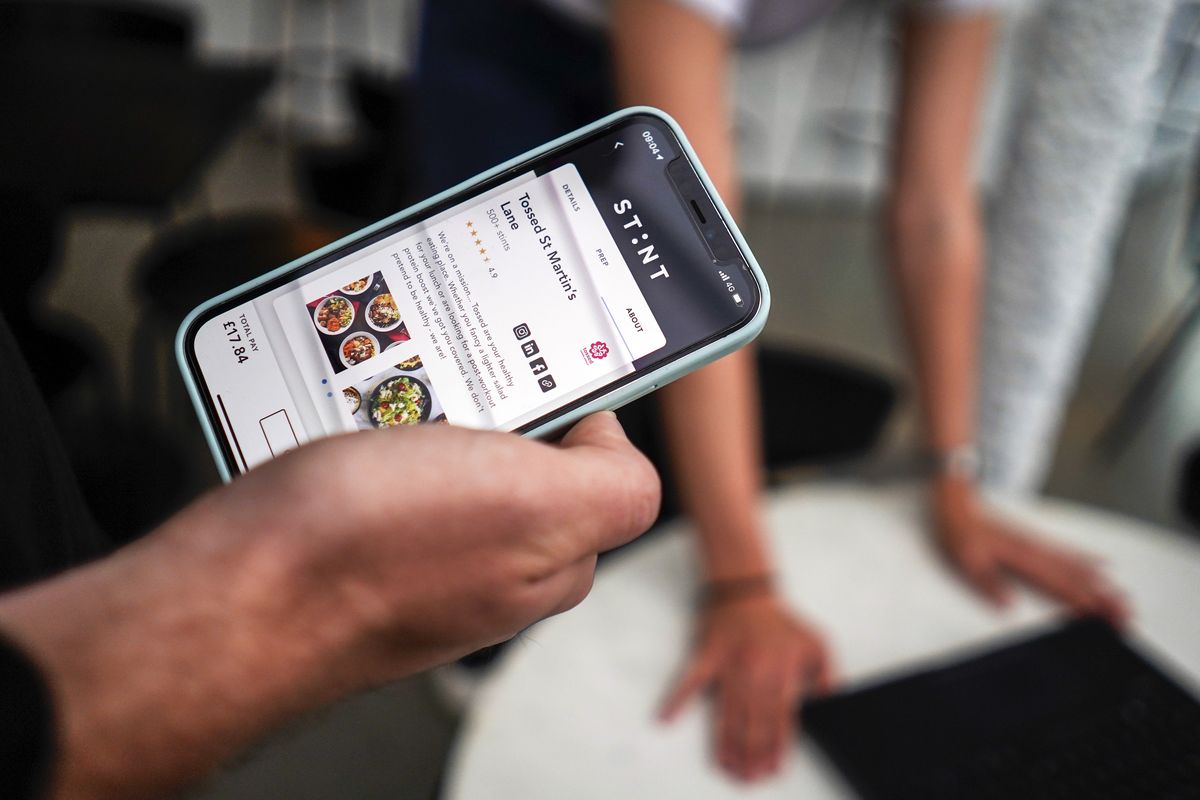 Sol Schlagman, co-founder of the app Stint, holds his smartphone displaying the app running.  (Associated Press)