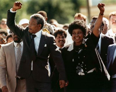 In this file photo dated Sunday, February 11, 1990, Nelson Mandela and wife Winnie, walk hand in hand, raising their clenched fists upon his release from Victor prison, Cape Town, 27 years in detention. (Greg English / Associated Press)