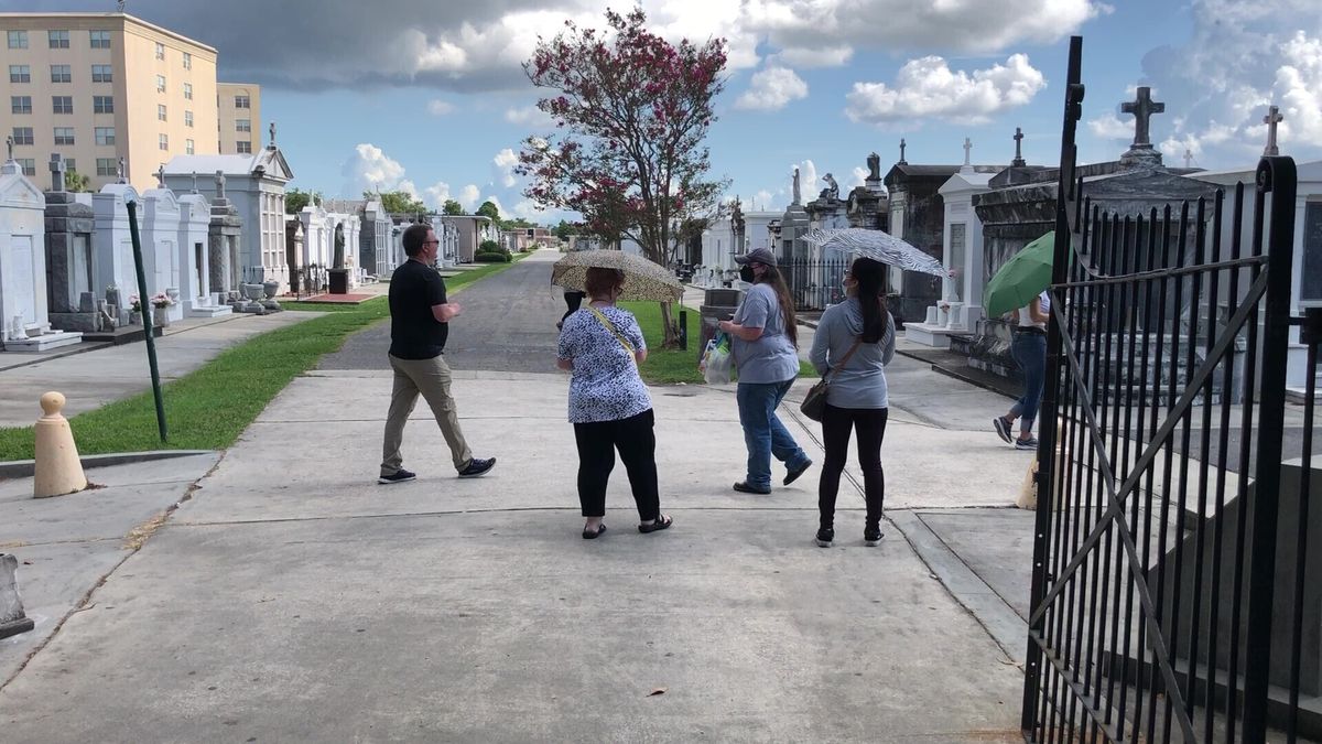 Tourists wander through a historic New Orleans cemetery on Thursday, Aug. 12, 2021. The city’s vital tourism industry was devastated by the COVID-19 epidemic in 2020. It had begun making a comeback in recent months as vaccines have become available. But the spread of the highly contagious delta variant of the coronavirus and a low vaccination rate in Louisiana are being blamed for a resurgence of COVID-19 that has stressed hospitals and led to cancellations, for the second year, of tourist-drawing events.  (Kevin McGill)