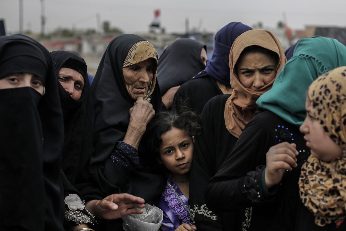 Mosul residents wait at a food distribution point Tuesday in western Mosul, Iraq. As Iraqi forces continue to make slow progress in the fight against the Islamic State group in Mosul, food supplies are running dangerously low for civilians trapped inside militant-held territory and those inside recently retaken neighborhoods. (Bram Janssen / Associated Press)