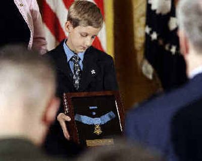 
David Smith, 11, looks at the Medal of Honor after it was presented to him by President Bush on Monday. 
 (Associated Press / The Spokesman-Review)