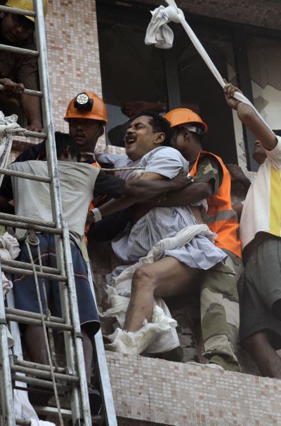 Fire officials rescue a patient from the window of a hospital after it caught fire in Kolkata, India, on Friday. (Associated Press)