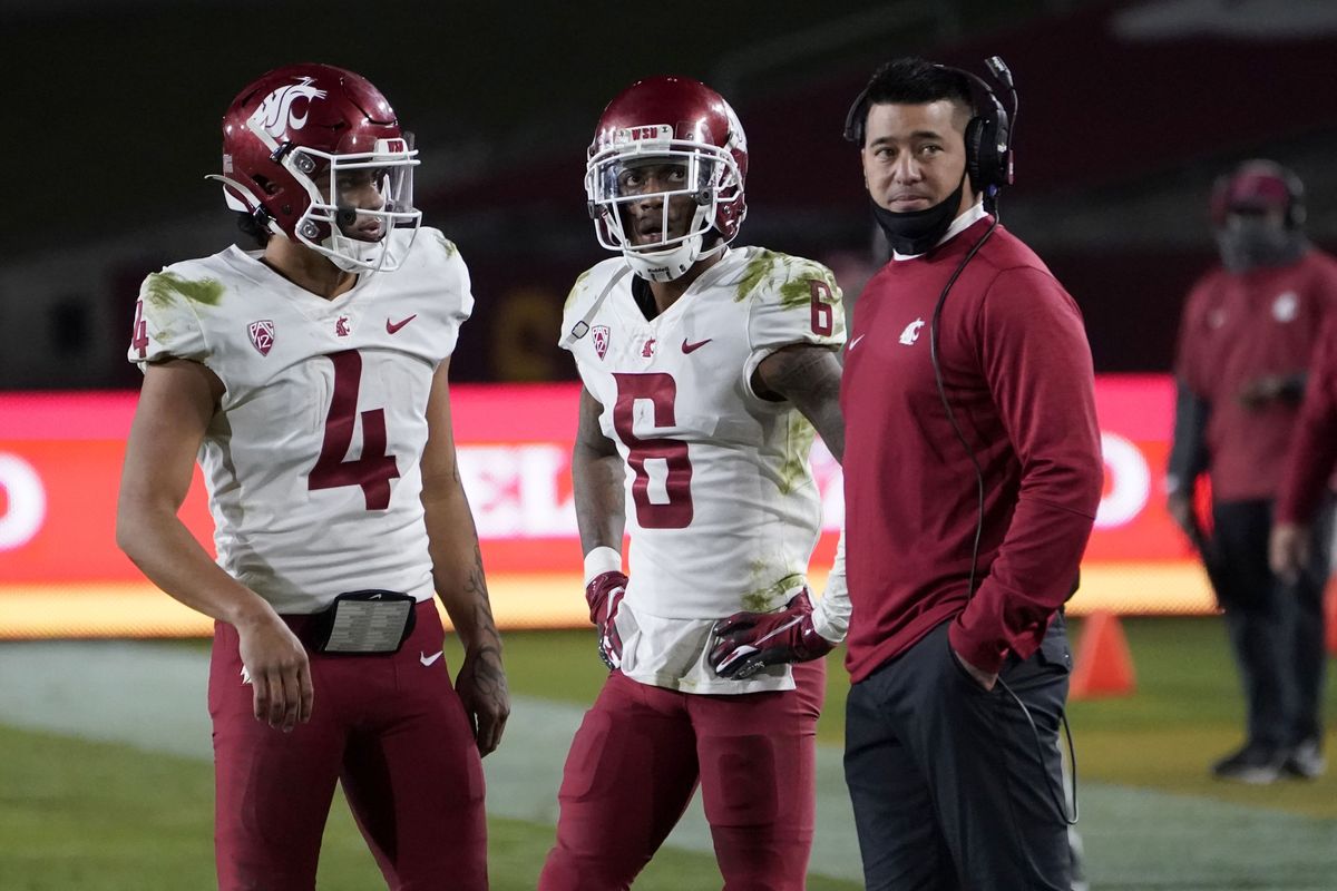 Washington State quarterback Jayden de Laura (4) and wide receiver Jamire Calvin (6) look on with co-offensive coordinator Craig Stutzmann during the second half of an NCAA college football game against Southern California in Los Angeles, Sunday, Dec. 6, 2020.  (Associated Press)