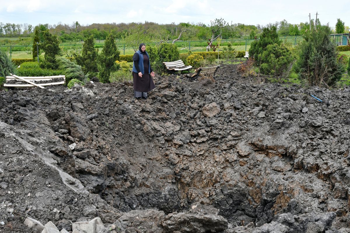 Orthodox Sister Evdokia gestures in front of the crater of an explosion, after Russian shelling next to the Orthodox Skete in honour of St. John of Shanghai in Adamivka, near Slovyansk, Donetsk region, Ukraine, Tuesday, May 10, 2022.  (Andriy Andriyenko)