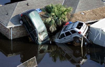 
Two cars sit on top of a home surrounded by floodwaters from Hurricane Katrina in New Orleans. Experts are warning prospective car buyers to watch closely in the coming months for telltale signs of flood-damaged cars and trucks hitting the used car market. 
 (Associated Press / The Spokesman-Review)