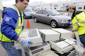 Murray Huppin, left, of Huppin’s Hi-Fi Photo &  Video, and Chad Miller, of Waste Management, stack and bundle outdated electronic equipment brought by a seemingly unending line of people passing through the Huppin’s Warehouse parking lot Saturday.  (Photos by JESSE TINSLEY / The Spokesman-Review)