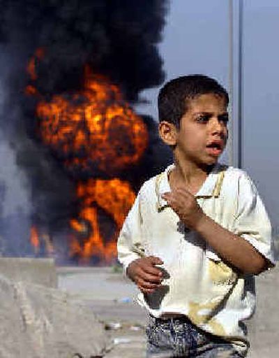 
An Iraqi boy stands near the scene where insurgents hit an American fuel-supply convoy Wednesday in Iraq.
 (Associated Press / The Spokesman-Review)