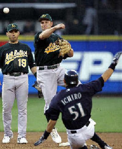 
Oakland second baseman Mark Ellis throws to first to complete a double play. 
 (Associated Press / The Spokesman-Review)