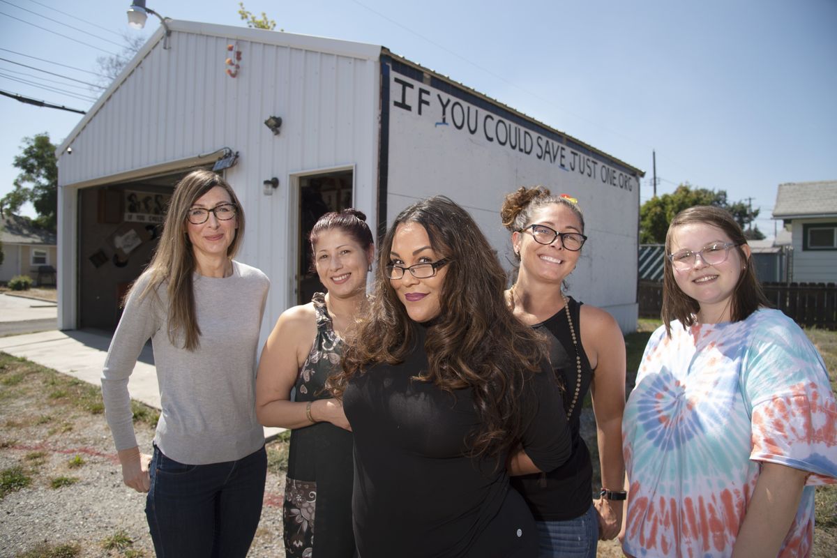 Natalia Gutierrez, center, founder of the nonprofit If You Could Save Just One, stands with members of her team, from left, Mandy Chapman-Orozco, Jennifer Gutierrez, Christina Rios and Anna Belov, outside an unused garage belonging to a local church on Nevada Street on Aug. 14. The building will be used for after-school programs, including art, music and writing, for kids.  (Jesse Tinsley/The Spokesman-Review)