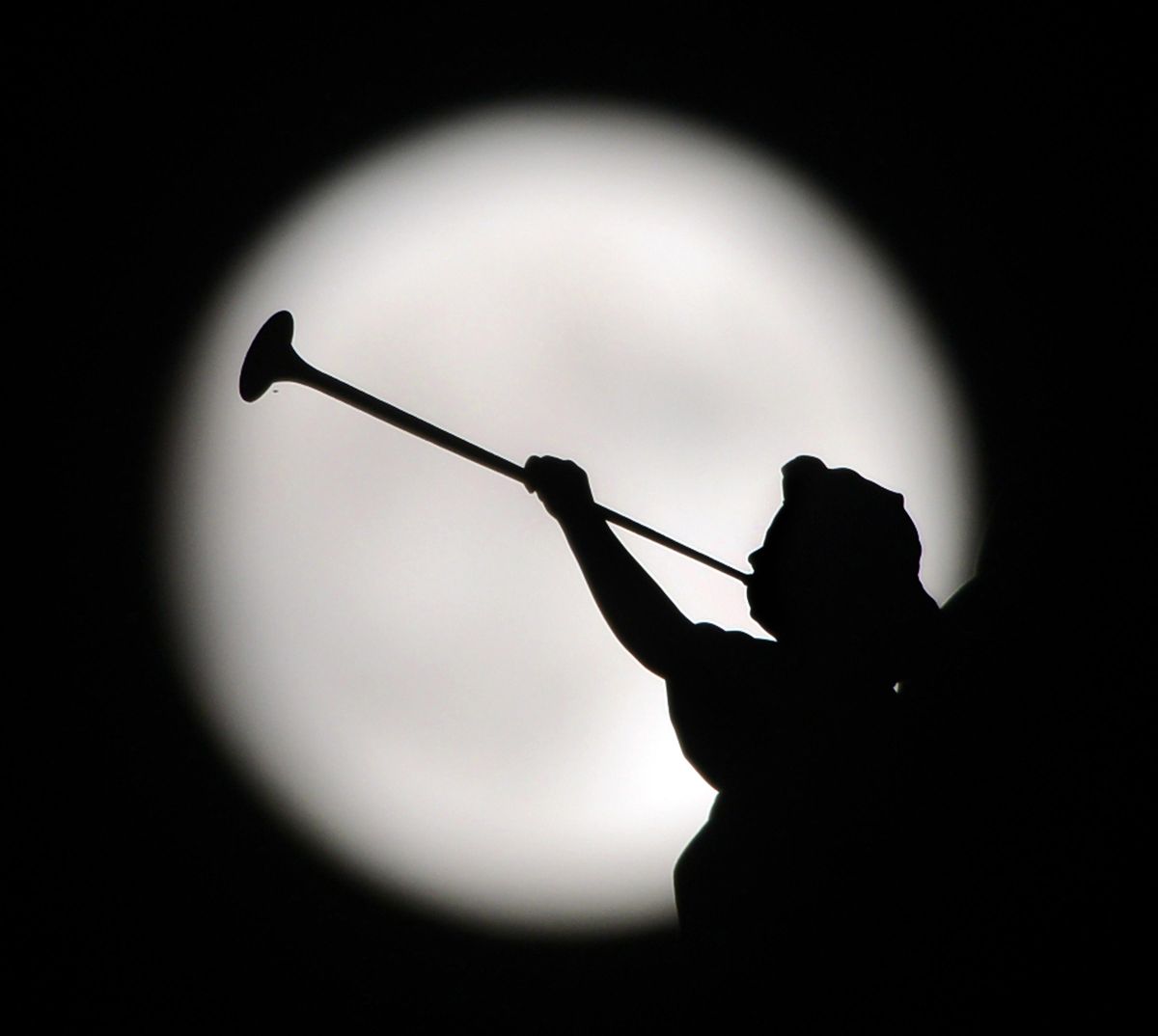 A statue of an angel playing a horn, at Saint Mary’s Byzantine Catholic Church, is silhouetted by the moon Sunday, in downtown Scranton, Pa. (Butch Comegys / AP)