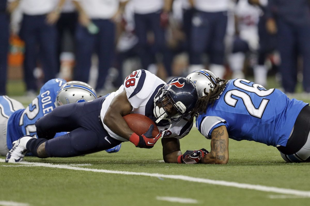 Texans running back Justin Forsett (28) goes down as he is hit by Lions’ Louis Delmas, but ended up with a TD on the play when a Detroit challenge went afoul. (Associated Press)
