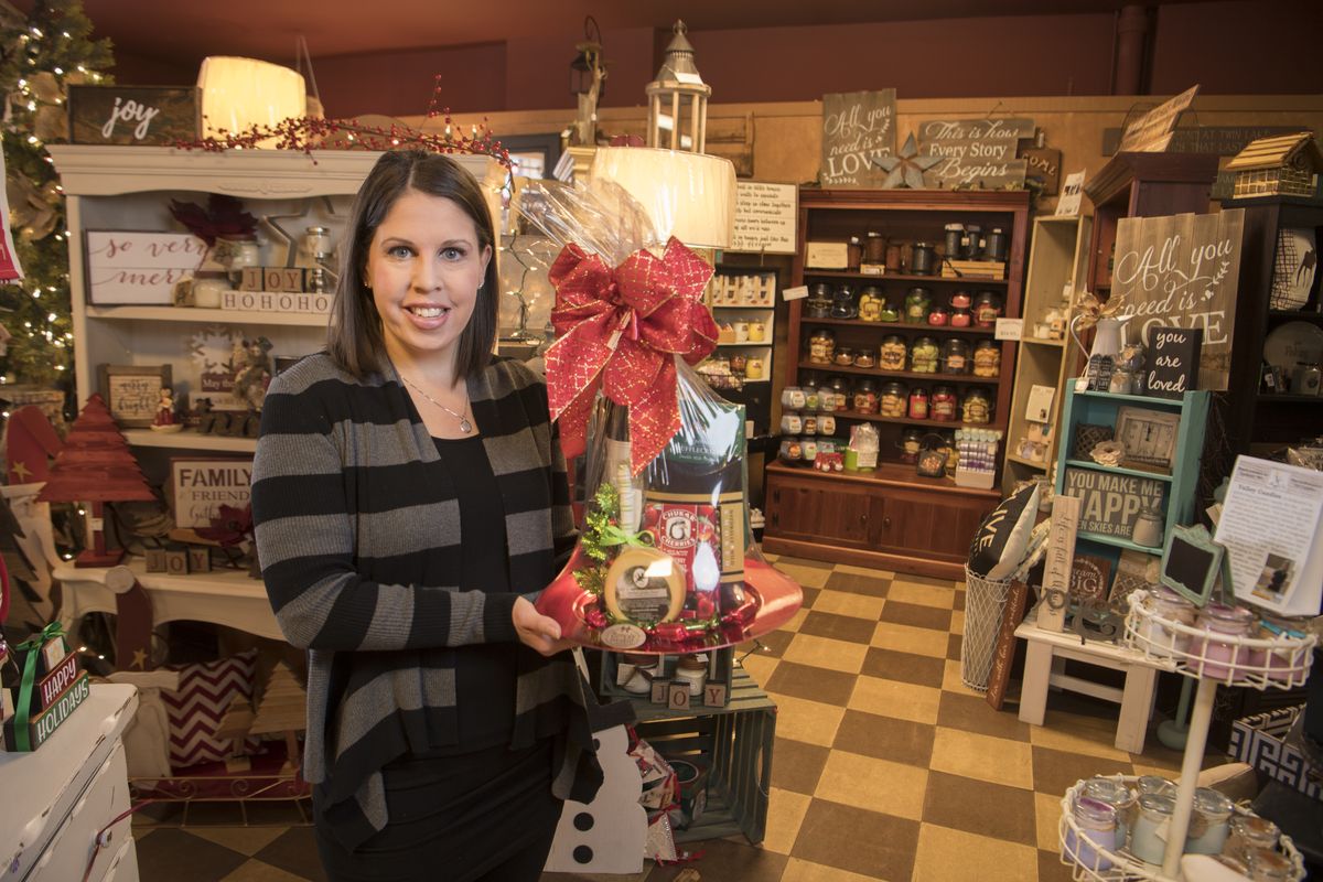 Denielle Waltermire Stuhlmiller holds a signature gift basket in her gift shop, Simply Northwest, on Wednesday, Dec. 13, 2017. Her store is at 11806 E. Sprague in Spokane Valley.  (Jesse Tinsley/The Spokesman-Review)