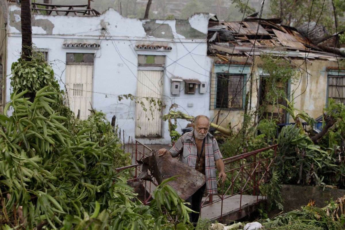A man tries to recover his belongings from his house destroyed by Hurricane Sandy in Santiago de Cuba, Cuba, Thursday Oct. 25, 2012. Hurricane Sandy blasted across eastern Cuba on Thursday as a potent Category 2 storm and headed for the Bahamas after causing at least two deaths in the Caribbean. (Franklin Reyes / Associated Press)