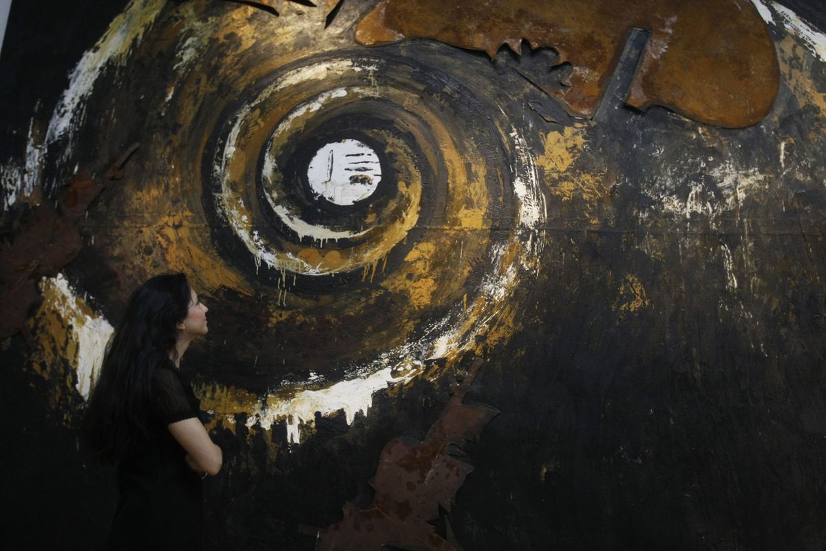 A Christie’s employee examines an untitled piece by Enzo Cucchi featured in an Italian sale.  (Associated Press / The Spokesman-Review)