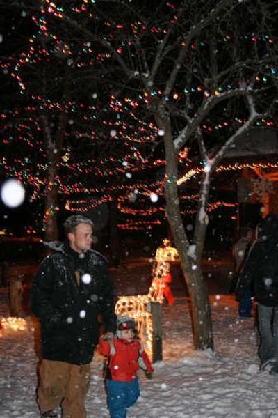 
Snow falls as visitors to Rathdrum D'lights Winter Festival enjoy the activities.
 (Mary Jane Honegger / The Spokesman-Review)