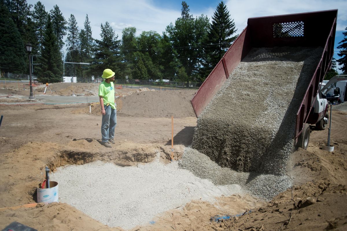 Land Expressions’ Micah Cole watches as Rock Wells, not pictured,  pours a layer of gravel for a concrete pad in a garden Monday at Whitworth University  in Spokane. (Tyler Tjomsland / The Spokesman-Review)