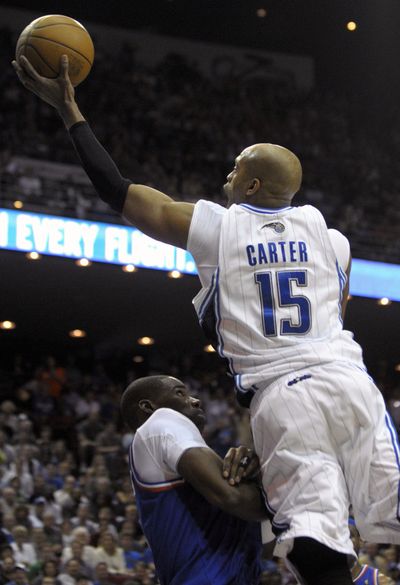 Orlando guard Vince Carter puts up a shot in front of Cleveland forward Antawn Jamison during the Magic’s win Sunday.  (Associated Press)