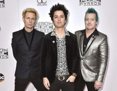 In this Nov. 20, 2016 file photo, Mike Dirnt, from left, Billie Joe Armstrong, and Tre Cool, of Green Day, arrive at the American Music Awards in Los Angeles. The band will release their latest, Greatest Hits: God's Favorite Band, on Friday. (Jordan Strauss / Invision via AP)
