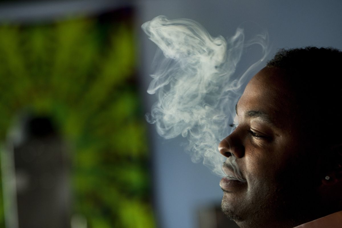 Eric Buchanan uses a “vape pen,” which emits a smokeless vapor, on Friday at The Lounge in Spokane Valley. (Tyler Tjomsland)