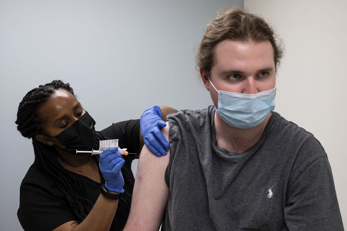 Cole Smith receives a Moderna variant vaccine shot from clinical research nurse Tigisty Girmay at Emory University