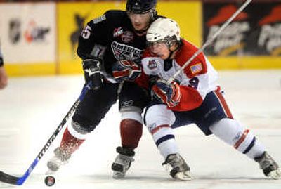 Tri-City's Colton Yellow Horn struggles for a loose puck with Spokane's Tyler Johnson during the second period at the Arena.
(Rajah Bose / The Spokesman-Review)