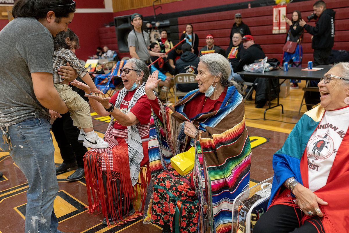 Women of Wounded Knee, Madonna Thunder Hawk, left, Yvonne Swan, center, and Mable Eagle Speaker, are greeted by guests during a Pow Wow to honor the AIM Warriors of Wounded Knee of 1973 in Wanblee, South Dakota on the Pine Ridge Indian Reservation on Sunday, Feb. 26, 2023.   (Elizabeth Flores/Minneapolis Star Tribune/TNS)