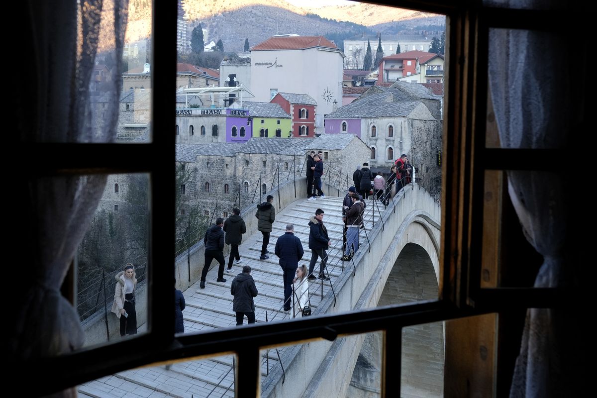 People walk over the historic Old bridge in Mostar, Bosnia, on Sunday. Divided between Muslim Bosniaks and Catholic Croats, the city had not held a local election since 2008.  (Kemal Softic)