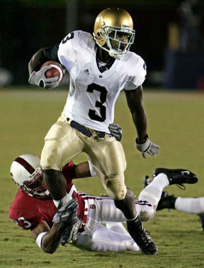 
Notre Dame running back Darius Walker gains yardage in front of Stanford safety Brandon Harrison in the first quarter on Saturday. 
 (Associated Press / The Spokesman-Review)