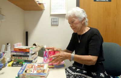 
Elaine Smith, a volunteer at the Rathdrum Library, tapes up new books to prevent damage. 
 (Jesse Tinsley / The Spokesman-Review)