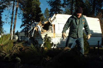 
Mike Maravilla negotiates broken limbs and tree trunks as he helps clean up the Tamarack RV park Saturday in Coeur d'Alene. 
 (Jesse Tinsley / The Spokesman-Review)