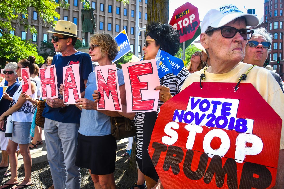 Protester display their signs outside the Spokane Club where a fundraiser for Congresswoman Cathy McMorris Rodgers was attend by California Congressman Devin Nunes, Monday, July 30, 2018. (Dan Pelle / The Spokesman-Review)