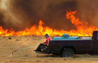 
Workers for farmer Wade McLean used a propane torch to light a grass field Tuesday, Aug. 15, 2006. 
 (File / The Spokesman-Review)