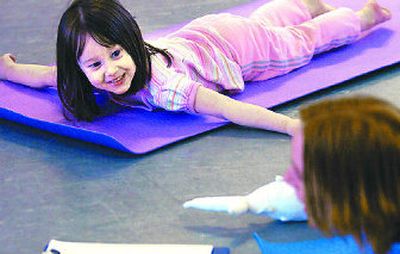 
Winter Haler, 4, smiles as she looks at her mother, Jennifer, while stretched out on her yoga mat during a Saturday morning class.
 (The Spokesman-Review)