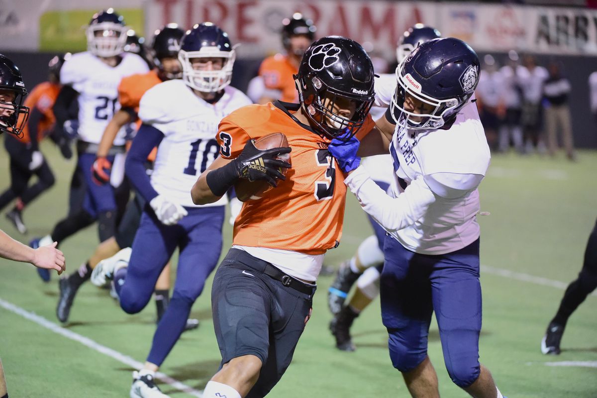 Lewis and Clark’s Xavier Guillory  tries to turn the corner with Gonzaga Prep’s Braeden Young, right, in his face Oct. 26 at  Albi Stadium. Guillory signed his appointment to the Air Force Academy on Wednesday  at Lewis and Clark HS. (Jesse Tinsley / The Spokesman-Review)