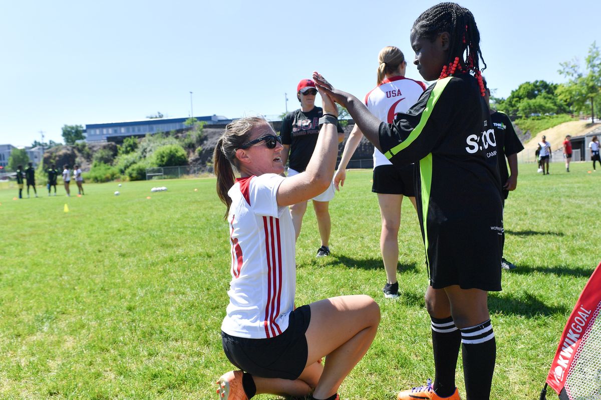USA Soccer’s Erica Jarmer, left, high-fives Dori Katunbi, 8, on Friday, during Thrive’s 2022 soccer camp at North Central High School in Spokane.  (Tyler Tjomsland/The Spokesman-Review)