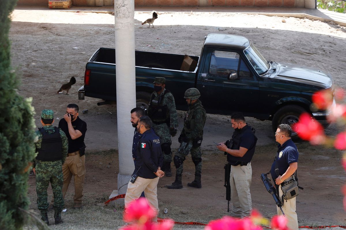 Army officers and Michoacan state prosecutors inspect the cockfighting site "El Paraiso," or Paradise in Zinapecuaro, Mexico, Monday, March 28, 2022. Nineteen people were killed the previous day when gunmen burst into the site, according to prosecutors in the western state of Michoacan.  (Armando Solis)