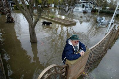 Ken Fischer, 62, watches the water Thursday in the front yard of his home in Ryer Island, Calif. The San Francisco Bay Area and counties farther north are likely to bear the brunt of the storms forecast to hit California today and Sunday.
(Associated Press / The Spokesman-Review)