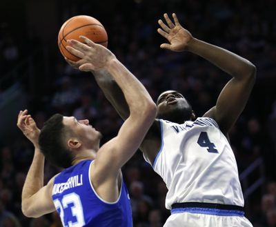 Villanova forward Eric Paschall, right, takes a shot over Seton Hall forward Sandro Mamukelashvili on Sunday in Philadelphia. (Laurence Kesterson / Associated Press)