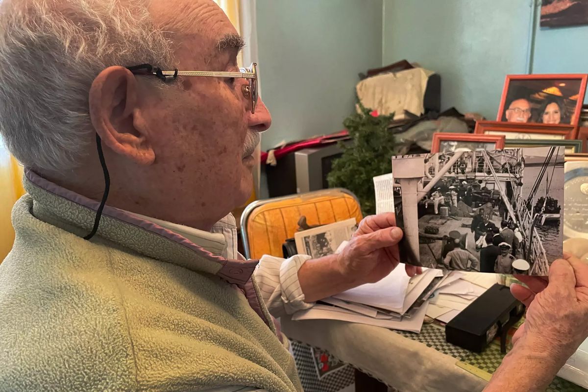 JosÃ© Enrique Cisterna, 95, looks at an old picture of the jail. Cisterna moved to Ushuaia at 18 and worked on the naval base that took over the prison.    (Leila Miller/Los Angeles Times/TNS)