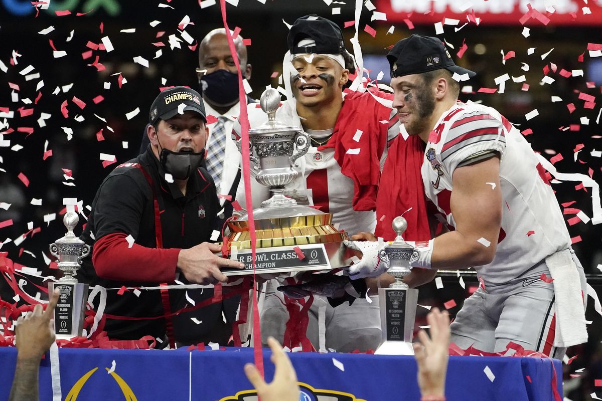 Ohio State head coach Ryan Day, from left, quarterback Justin Fields and linebacker Tuf Borland hold up the trophy after their win against Clemson in the Sugar Bowl NCAA college football game Saturday, Jan. 2, 2021, in New Orleans. Ohio State won 49-28. (Associated Press)