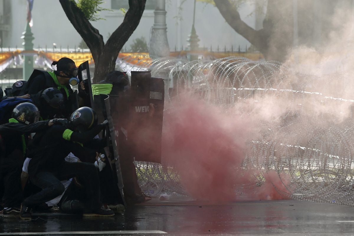 Riot police launch tear gas to protesters marching to Government House in Bangkok, Thailand Sunday, July 18, 2021. Hundreds of anti-government protesters rallied on Sunday despite the government’s recent measures to prohibit the gathering of more than 5 people in the capital to curb the COVID-19 pandemic. Protesters demanded the resignation of Prime Minister Prayuth Chan-ocha and his cabinet.  (Anuthep Cheysakron)