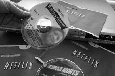 
Netflix customer Carleen Ho holds up DVD movies, 