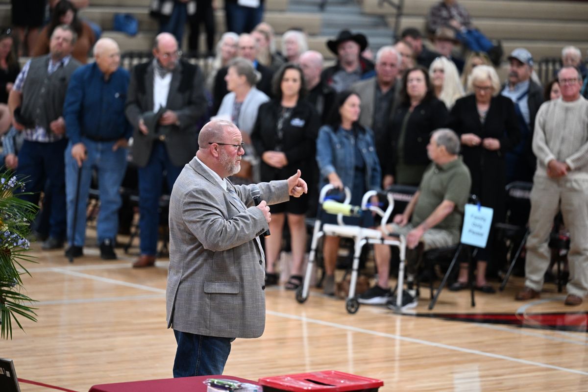 The audience stands after agriculture teacher Rick Perleberg, foreground, talks ask who was helped by or benefited from knowing Carl Grub, who died in the Medical Lake fire. He talked about how Grub contributed to youth programs like FFA and 4-H. A celebration of life service was held Saturday, Sept. 23, 2023 at Medical Lake High School.  (Jesse Tinsley/THE SPOKESMAN-REVIEW)