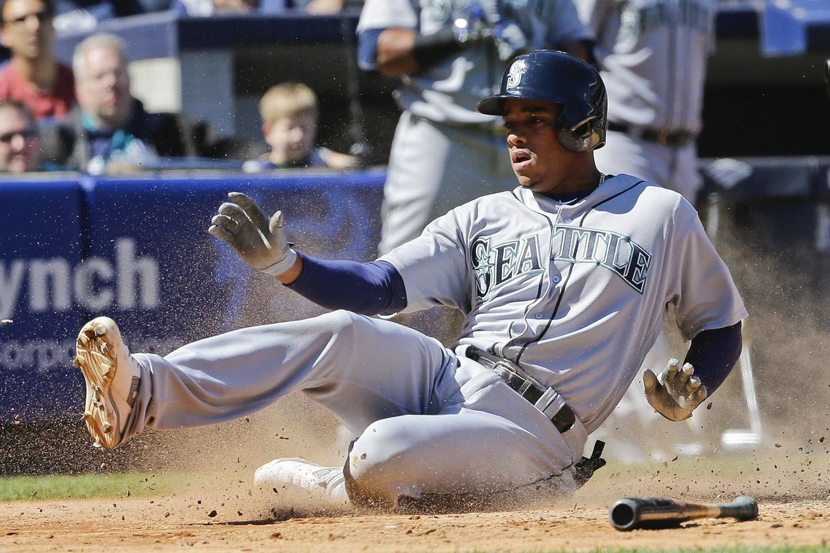 Mariners’ Ketel Marte slides to score on an RBI double by Robinson Cano during the fifth inning. (Frank Franklin II / Associated Press)