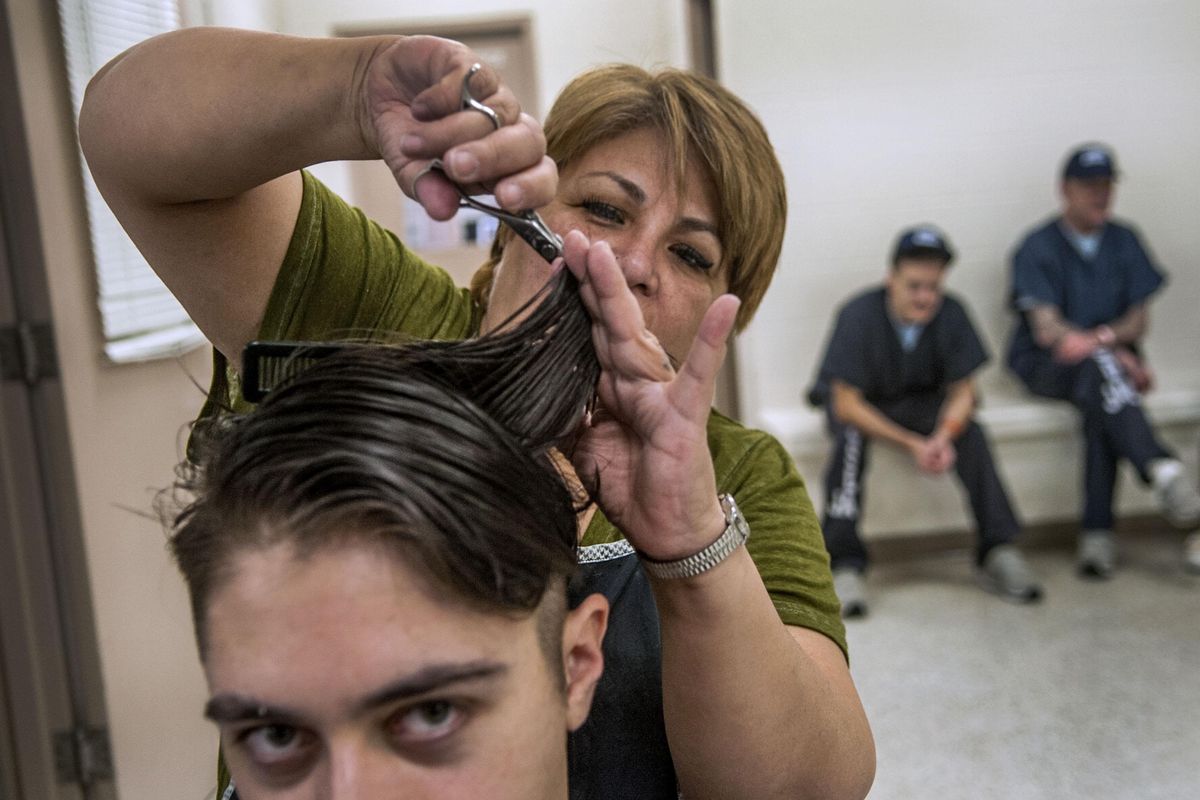 Leticia Serrano cuts inmate Bradford Curtis’s hair at the Kootenai County Jail in Coeur d’Alene on Dec. 19, 2017. She’s volunteered there for over 17 years. (Kathy Plonka / The Spokesman-Review)