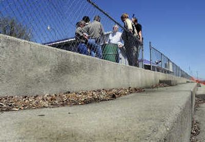 
Contractors, consultants and  Spokane County representatives tour Spokane Raceway Park on Thursday. Don Schumacher, center, listens as the group discusses cleanup at the site, which is littered with garbage  including abandoned cars, ambulances and a railroad freight car. 
 (Christopher Anderson / The Spokesman-Review)