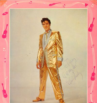 When Elvis performed at Joe Albi Stadium in 1957, my father, Marvin Winton, was assistant manager for the old Coliseum. Before Elvis’ show, in a noisy, smoke-filled room full of security people and musicians in the little brick administration building at the end of the Stadium, I was a freckled, awkward little 10-year-old girI lost in all the commotion, trying to stutter out a request for an autograph before I died of fright. Elvis Presley, who was limbering up, waiting to perform on a plywood stage in the middle of a football field, bleachers full of screaming girls, stopped and actually asked my name. He autographed a picture of himself in a gold lame’ suit.
(Terry (Winton) Omans)